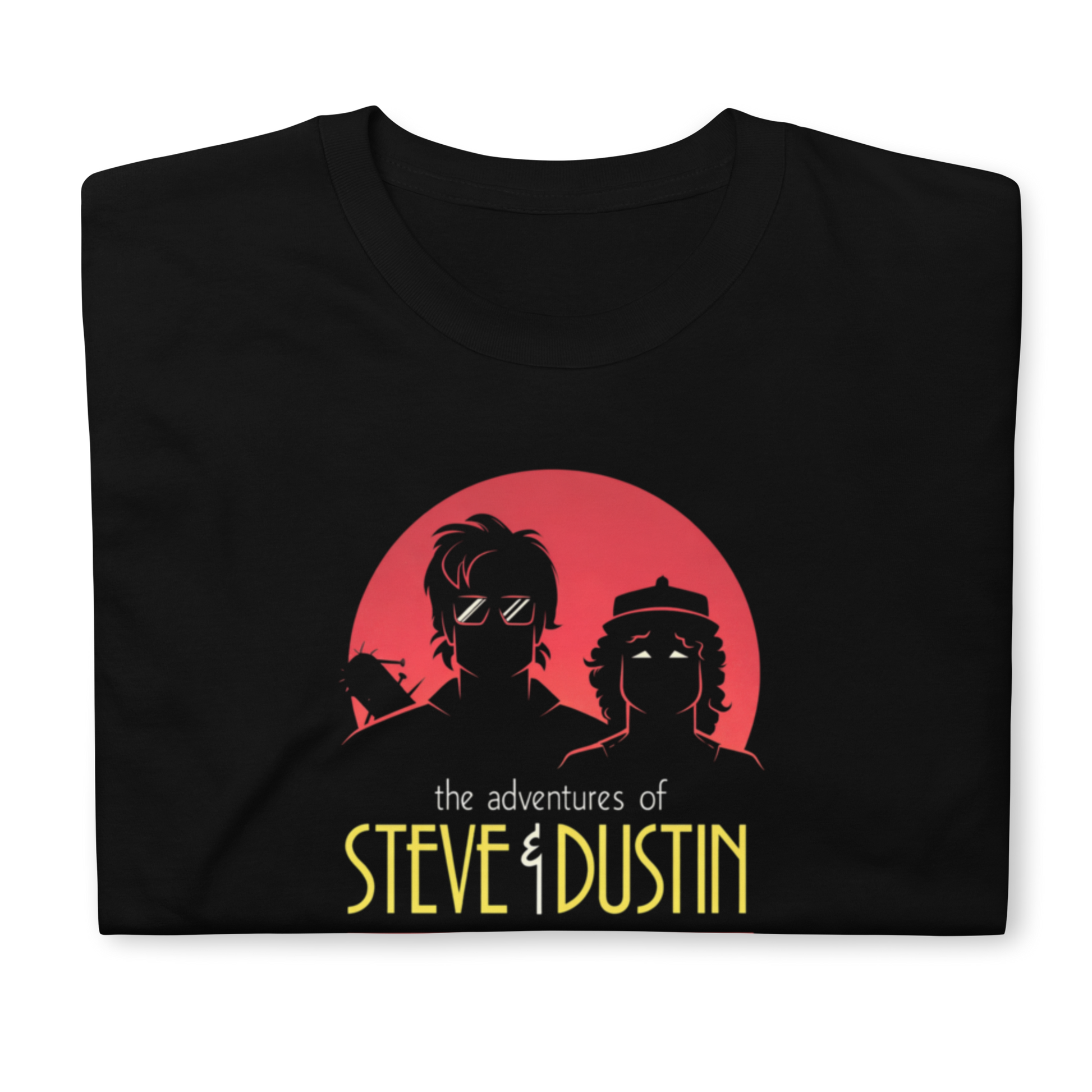 Modelo luciendo camiseta negra con diseño de Steve Harrington y Dustin Henderson estilo Batman y Robin de los 80, colección Hawkins Things de PEGHASO. Camiseta Stranger things